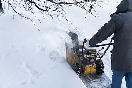 暴风雪过后 男子用造雪机清理车道 在街道上工作的除雪设备 从雪中清理街道 正在下雪车辆技术男性工具投掷者机械蓝色引擎机器雪堆背景