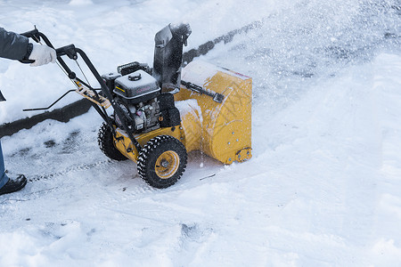 暴风雪过后 男子用造雪机清理车道 在街道上工作的除雪设备 从雪中清理街道 正在下雪投掷者打扫男性工具行动拖拉机机器技术车辆机械背景