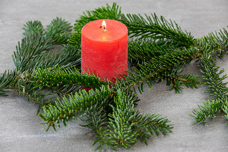 圣诞主题纹理背景 带有诺德曼冷杉的树枝和深灰色大理石背景上燃烧的红蜡烛大理石纹白色红色植物松针墙纸绿色背景图片
