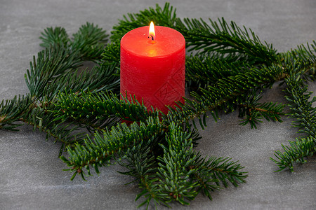 圣诞主题纹理背景 带有诺德曼冷杉的树枝和深灰色大理石背景上燃烧的红蜡烛松针植物大理石纹白色墙纸绿色红色背景图片