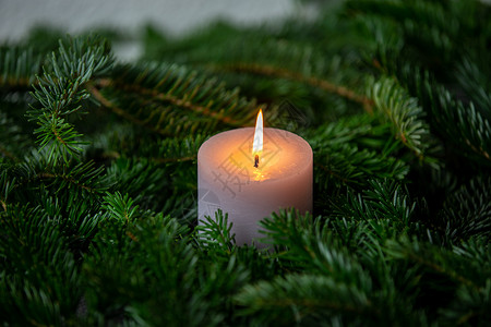 圣诞主题纹理背景 带有诺德曼冷杉的树枝和深灰色大理石背景上燃烧的白色蜡烛墙纸植物大理石纹绿色松针背景图片