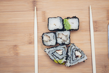 三边寿司卷筷子 木板日式日本菜海藻盘子黄瓜菜单海苔美味食物美食芝麻蔬菜背景图片
