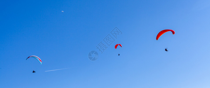 跳降落伞滑翔在乡村上空的降落伞上冒险活动行动翅膀飞行员季节空气蓝色旅行风险背景