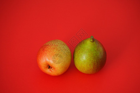开菜果 红底的两颗美丽的梨子维生素收成美味农业黄色食物甜点红色花园背景图片
