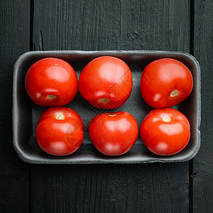 黑色木制桌上的新鲜红有机番茄背景图片