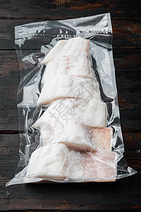 锡纸包鱼无皮肤的鱼 塑料真空 包装在深木木本底背景