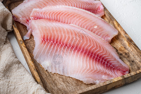 白底的蒂拉皮亚鱼片肉海鲜粉色白鱼背景图片