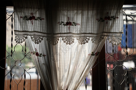 靠近玻璃窗的手工钩针棉布窗帘玻璃织物窗户纺织品装饰品背景图片