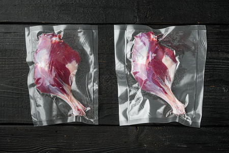 黑塑料包生鸭腿肉 装在密封袋中 用于做苏的副烹饪 黑木制桌底 顶楼背景
