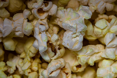 宏选择性地关注有黄油的爆米花小吃宏观食物电影谷物工作室团体盐渍流行音乐玉米背景图片