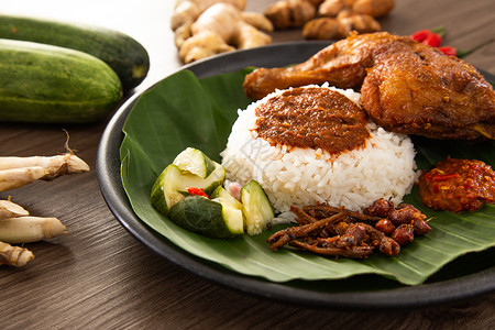 吉兰丹Nasi Kukus通常由新鲜蒸米和脆烤炸鸡组成米饭香料马来语鸡翅美食传统食物蒸汽咖喱汁盘子背景