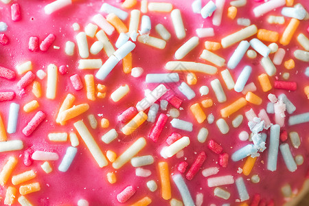 糖喷洒的粉红色甜甜甜圈带 贴近画面甜点蛋糕甜食糖链享受生活方式庆典粉色糖霜糖果背景