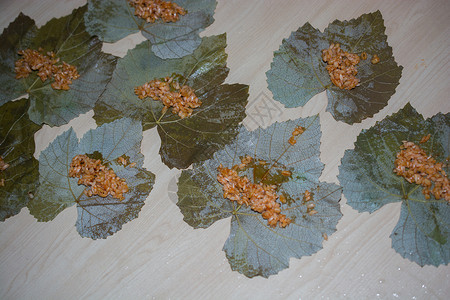 准备加饭和肉或传统沙马的松树叶用餐盘子绿色藤蔓叶子美食厨师烹饪脚凳蔬菜背景图片