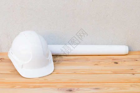 工程案列白色安全头盔塑料塑料和纸卷计划蓝图 在木制地板表背景上建筑工程 并加上增加案文的复制空间工作工具桌子地面承包商水泥老板安全项目建背景