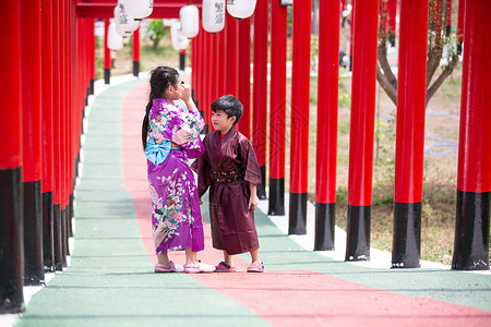 赏荷孩子两个和服里的小孩 走进圣殿红门 在日本花园里旅行神道传统人行道隧道女性文化旅游裙子戏服背景