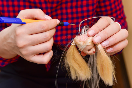 女性手和自制工具 如何为玩偶制造发型 爱好概念背景图片