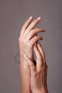 在指甲上涂有浅粉红色美甲的 美女手的近视图像背景图片