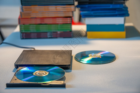 录音机播放机CD和DVD磁盘的精密视频播放器 背景中有许多电视系列电影光盘礼物电缆生产齿轮录音机技术电视剧学习教学娱乐背景