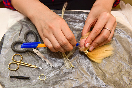 女性手和自制工具在桌上 如何为玩偶做发型 爱好概念手工文化塑像衣服玩具手指抛光调色板机器娃娃背景图片