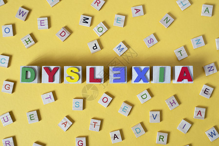 黄色背景中心有 DYSLEXIA 字词的木形字母块背景图片