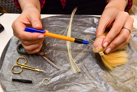女性手和自制工具在桌上 如何为玩偶做发型 爱好概念机器玩具配饰工艺抛光手绘手工生产手指塑像背景图片