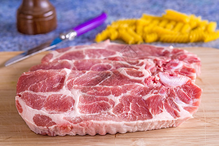 特写后 生猪排热量熟食动物条纹食物脖子牛扒粉色红色背景图片