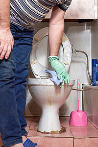 一个人用抹布擦洗脏马桶的边缘 清洗厕所高清图片