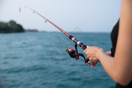 手线钓鱼素材手持有海背景的钓鱼杆 在日落时捕鱼的妇女假期猎人海洋海滩女性环境旅行海上生活爱好运动背景
