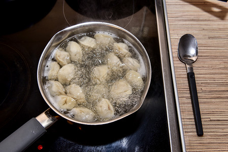 俄国人用沸水中龙卷风煮开的锅里 将猪排在沸水中勺子饮食食谱水饺饺子产品厨具烹饪面团营养背景图片