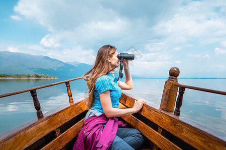 女人在船上 用望远镜看鸟的船上活动鸟类旅游游客双目高清图片