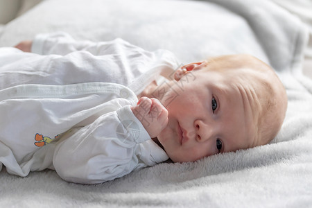 产褥期美丽的新生男孩躺在毯子上休息背景