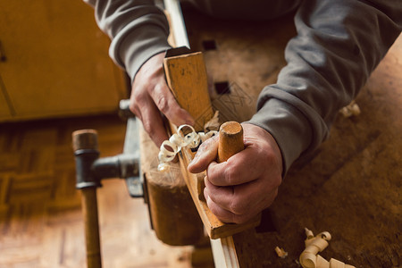 与木板工人一起工作的木匠手的顶端视图工艺制造商刨床木材工匠体力劳动作坊木刨刨花男人背景图片