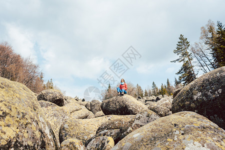 妇女徒步一条石河金桥巨石山脉石头岩石远足者风景背景图片