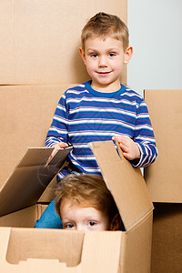家庭搬进他们的新家搬迁隐藏托运盒子快乐儿子纸盒开箱包装儿子们背景图片
