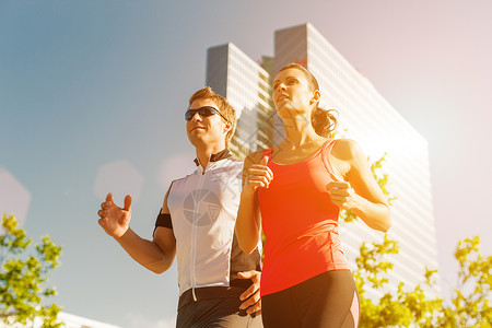 城市运动城市里的跑步健身男人运动员场景建筑慢跑者训练夫妻天际女士摩天大楼背景图片