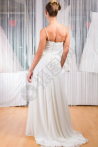 在店里试婚纱的妇女裙子专家女性店铺房间配件购物新娘女士背景图片