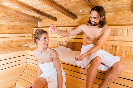芬兰浴坐在健康水疗浴桑拿的一对夫妇客户客人奢华出汗木头享受旅行剥皮女士夫妻背景