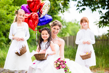 伴娘腕花与女伴新娘为伴娘 鲜花和气球女儿快乐花瓣孩子白色庆典女孩们女士篮子孩子们背景