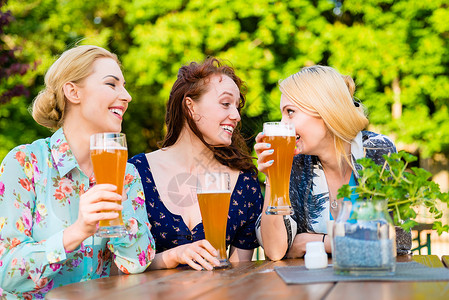 喝啤酒女孩朋友们在花园酒吧喝啤酒乐趣眼镜酒精女性玻璃饮料女孩们花园啤酒友谊背景