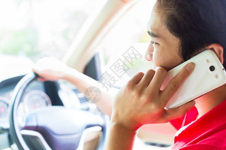 亚洲人驾驶汽车时用电话通话交通人们车辆男性手机罪行车轮司机背景图片