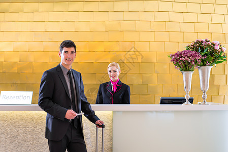 提供钥匙卡的男子在旅馆接待员检查接待商务工作女士办公室商业前台男人桌子客人图片