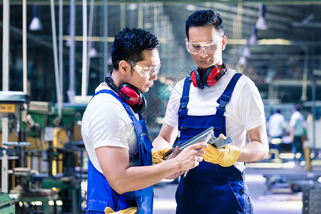亚洲工人在生产工厂中检查工作证的亚洲工人背景图片