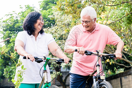 活跃的老年夫妇在自行车上站立的肖像夫妻灵活性爱好公园植被妻子机动性棉布丈夫活力牙齿高清图片素材