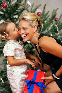 - 圣诞节的孩子亲吻她的母亲背景图片