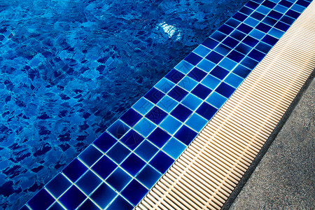 游泳池旁的蓝色陶瓷地板和排水槽背景图片
