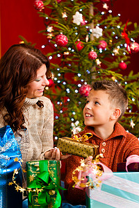 圣诞节  圣诞夜有礼物的家庭妈妈男生展示儿子孩子女士母亲喜悦父母惊喜背景图片