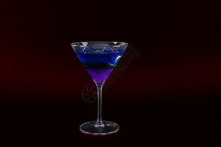 伏特加马提尼鸡尾酒杯中多彩多彩的饮料 加冰块 夏季饮料背景柠檬蓝色水果黑色奇异果派对酒吧蓝橙玻璃背景
