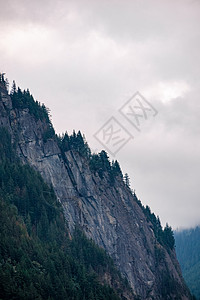 汉拿山山顶深处的岩石悬崖 四周是树丛 在天上覆盖着天空背景背景