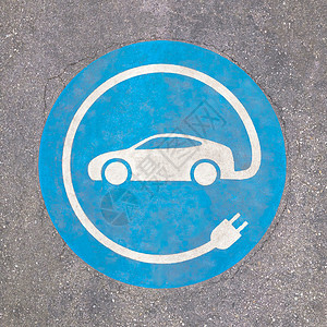插头标志EV -沥青充电站标志 沥青纹理上的E号标志背景