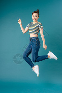 身穿脱条纹T恤衫和蓝底牛仔裤舞的混血女孩背景图片